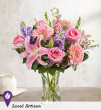 Pink roses, oriental lilies, gerbera daisy, snap dragon, larkspur flower, stock , greens and fillers in  clear gathering vase. Arrangement for Valentine's day, mothers day, anniversary and romantic occasions